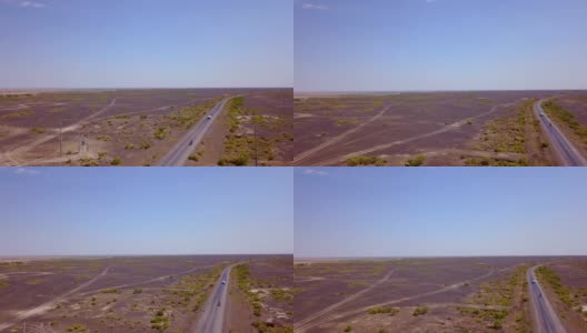汽车在沙漠中空旷的道路上行驶的鸟瞰图高清在线视频素材下载