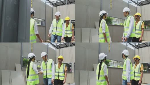亚洲结构工程师和工人在建筑工地握手。所有人在建筑工地行走时须戴上安全帽。商业交易、并购概念高清在线视频素材下载