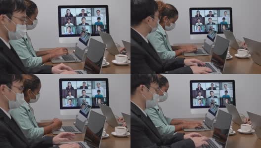 年轻的亚洲员工和资深的办公室员工团队通过电脑进行Zoom视频电话会议，商务人士共用办公桌使用电脑共同工作高清在线视频素材下载