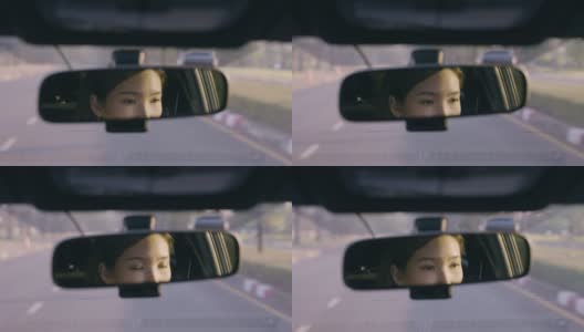 近距离亚洲妇女驾驶汽车反映在后视镜上的道路高清在线视频素材下载