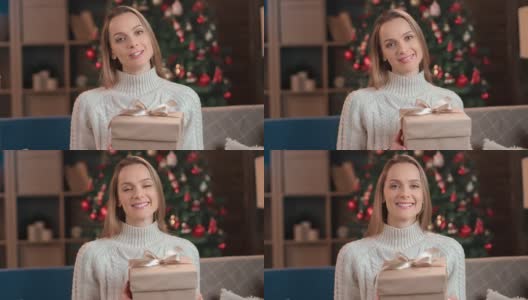 肖像女子在温暖的毛衣摆造型与节日礼物盒圣诞树冬季节日祝贺高清在线视频素材下载