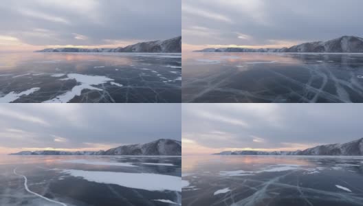 北方景观冻结湖无人机飞行下来与美丽的反射在日落4K。令人惊叹的冬季贝加尔湖和红色的日出。观看无人机在北方霜冻湖上的飞行。自然反射日落高清在线视频素材下载