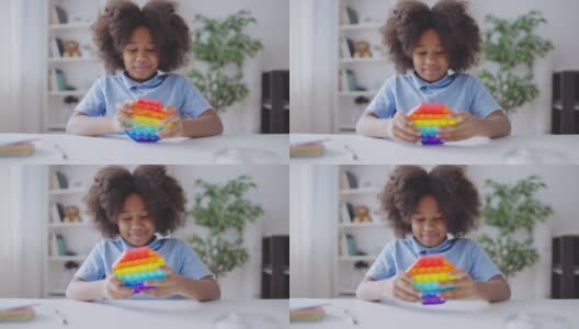 非裔美国女孩玩着烦躁玩具，按下按钮，缓解压力高清在线视频素材下载
