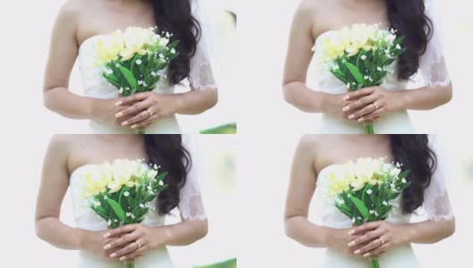 新娘捧着花束在花园里高清在线视频素材下载