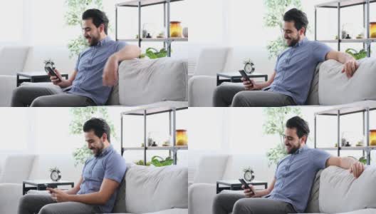 年轻人坐在沙发上玩手机高清在线视频素材下载