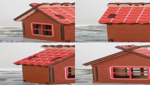 小型家庭住宅的模型站在美元钞票的背景上，缓慢地旋转。高清在线视频素材下载