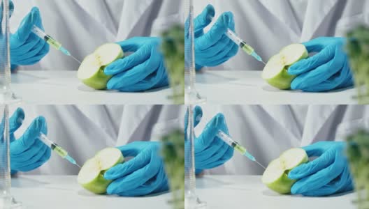 检查苹果的医学科学家，在实验室工作。食品研究，产品基因改造。微生物学家分析实验室培育的水果。高清在线视频素材下载