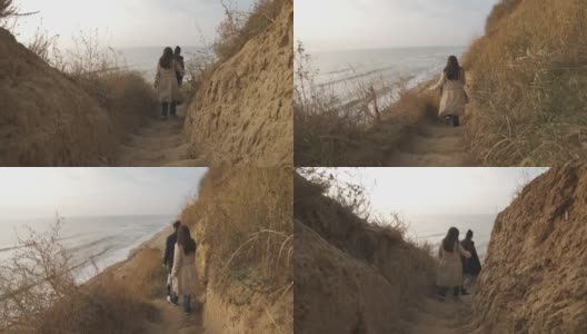 日落时分，一对幸福的情侣走下楼梯，来到狂野的海滩高清在线视频素材下载