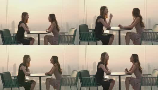 4K亚洲女性朋友在夏天的日落时分在摩天大楼的屋顶餐厅聚会。高清在线视频素材下载