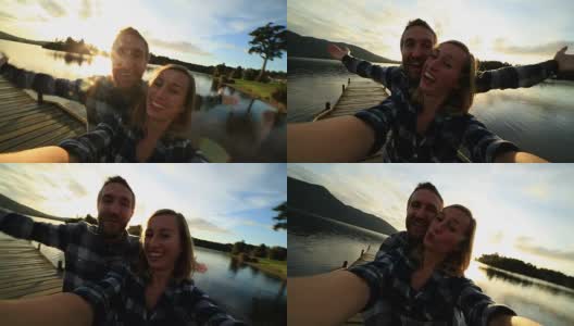 年轻夫妇在湖边码头的自画像高清在线视频素材下载