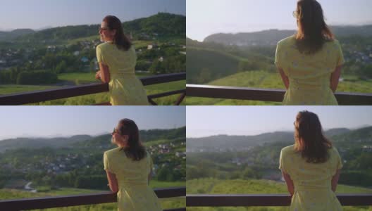 山间现代生态酒店的观景台，女人在享受夏日美景高清在线视频素材下载