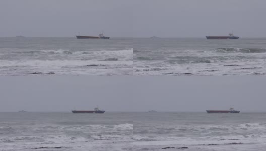 在暴风雨天气下波涛汹涌的海面上，一艘油轮沿着一艘领航船和一艘军用船的镜头在背景中出现高清在线视频素材下载
