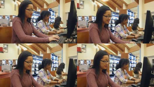 年轻的亚洲女大学生在图书馆的台式电脑上完成作业高清在线视频素材下载