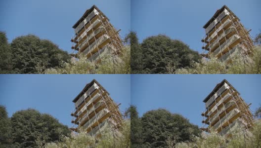 图中塔被一个旧堡垒的脚手架覆盖，被绿色植被包围高清在线视频素材下载