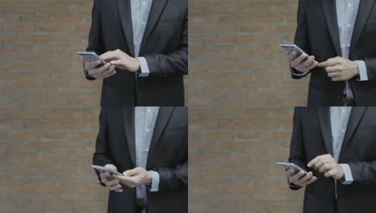 商人手触摸智能手机与砖的背景高清在线视频素材下载