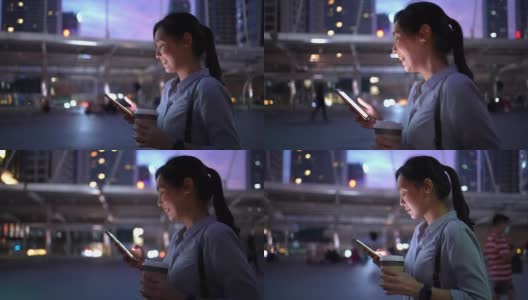 女商人在晚上走路时使用智能手机高清在线视频素材下载