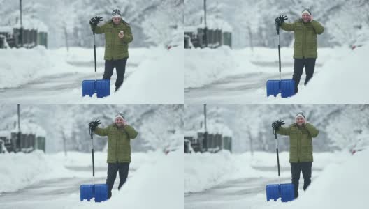 一个男人在铲雪的时候打电话高清在线视频素材下载