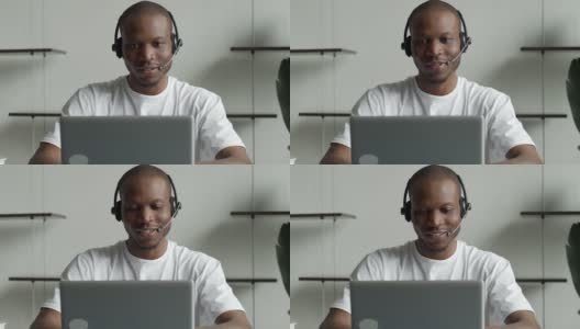 一名黑人男子是一名戴着免提耳机在办公室工作的客服人员高清在线视频素材下载