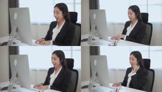 Smiley亚洲商务女接待员戴耳机视频会议电话，在电脑上通过网络摄像头在网上聊天，客户支持服务。高清在线视频素材下载