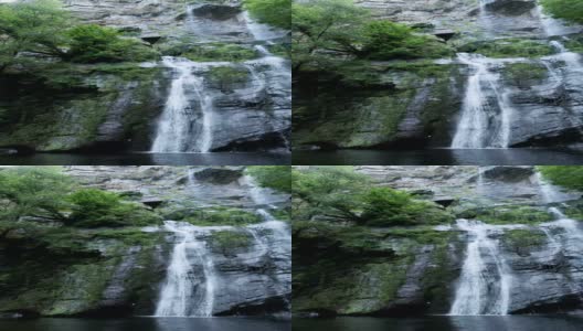 树木和岩石之间的天然瀑布高清在线视频素材下载
