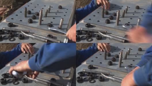 工人们用扳手拧紧固定铁路桥金属板的螺丝高清在线视频素材下载