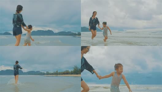 亚洲年轻母亲和她的小女儿在海边跑步高清在线视频素材下载