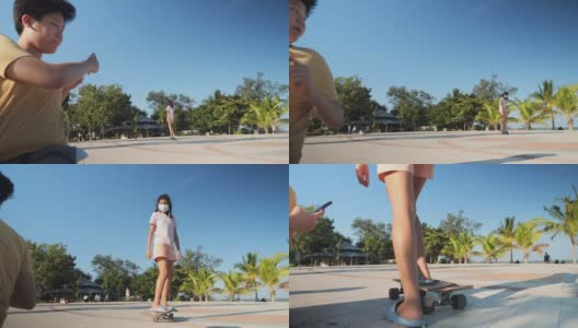 在阳光明媚的日子里，一个亚洲男孩试图给他的妹妹在公园玩滑板的时候拍照。高清在线视频素材下载