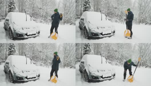 大雪过后，一名男子拿着铲子，若有所思地站在积雪覆盖的汽车旁。冬天天气恶劣，自然灾害严重。由于暴风雪，清理后院区域的人员。高清在线视频素材下载