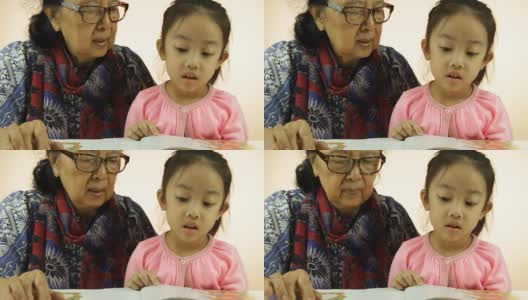 亚洲小女孩和奶奶在看书高清在线视频素材下载