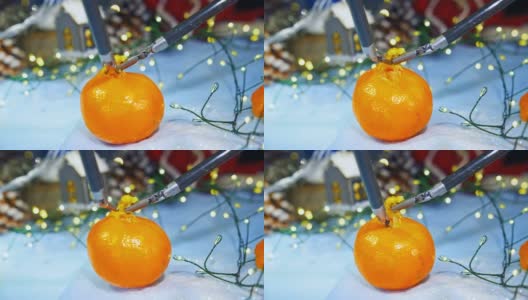 圣诞节剥橘子皮的新技术。用现代高科技设备准备新年。特写镜头。高清在线视频素材下载