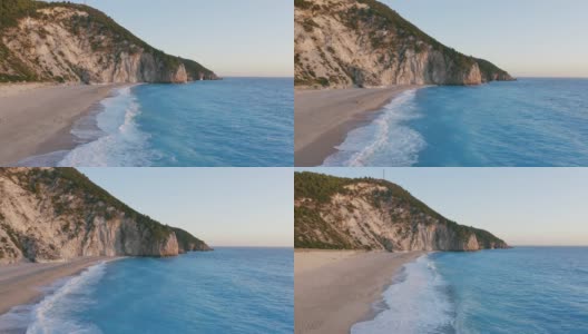 鸟瞰希腊爱奥尼亚岛莱夫卡达美丽的米洛斯海滩。夕阳金色的阳光和原始的海浪打破了蓝绿色的大海在岸边高清在线视频素材下载