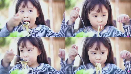 小女孩在吃美味的意大利面。高清在线视频素材下载