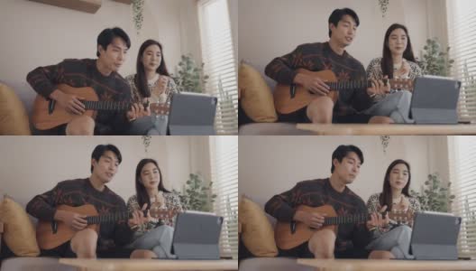 年轻男子和年轻女子在家里用社交媒体弹吉他唱歌高清在线视频素材下载