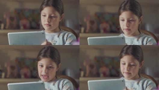 一个快乐的小女孩的真实照片是在她的房间里用平板电脑与朋友或亲戚进行有趣的自拍或技术视频通话。理念:技术、家庭、联系、新一代高清在线视频素材下载