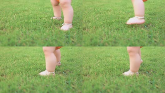婴儿第一次在草地上行走，慢镜头，摄影车拍摄。高清在线视频素材下载