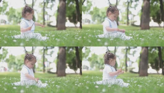 小女孩坐在草地上，抚摸着她的树枝，享受着大自然高清在线视频素材下载