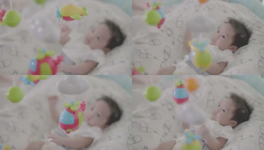 可爱的亚洲宝宝在床上玩挂手机。高清在线视频素材下载