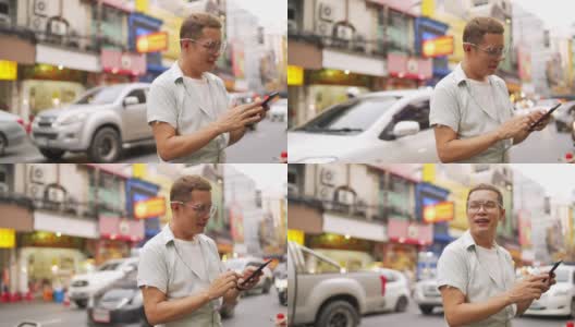 泰国曼谷夜市，一名4K亚洲男子在使用智能手机旅行高清在线视频素材下载
