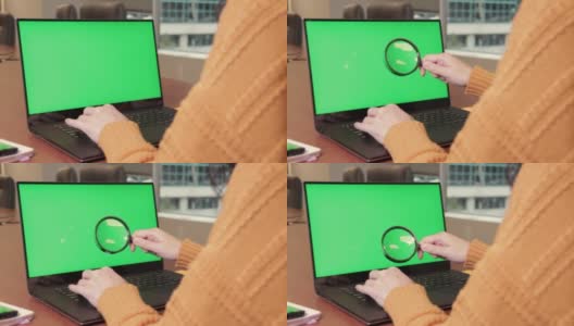 年轻女子在笔记本电脑上打字，拿着放大镜检查绿色屏幕上的东西，把它拿近一点。色度键,模型高清在线视频素材下载