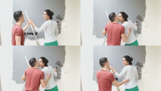 情侣在用油漆滚筒刷墙时接吻高清在线视频素材下载