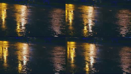 在城市的夜间道路上，汽车开进大水坑，车轮下溅起水坑高清在线视频素材下载