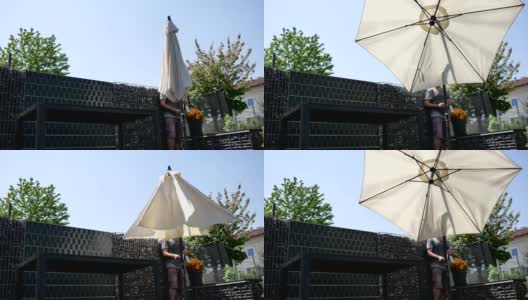 一个男人在阳台上撑开遮阳伞高清在线视频素材下载