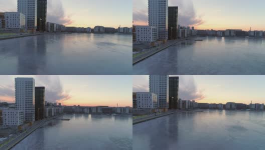 航拍现代公寓楼旁边的结冰的湖，瑞典斯德哥尔摩。日落时分，一架无人机飞过当代住宅区上空高清在线视频素材下载