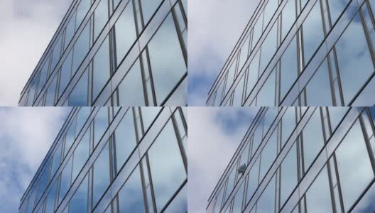 蓝色的夏日天空，云朵反射在办公大楼的玻璃幕墙上高清在线视频素材下载