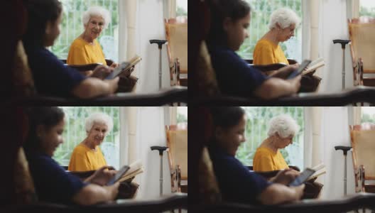 孙女在用手机，奶奶在看书高清在线视频素材下载