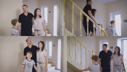 一个年轻的家庭走下他们新家的楼梯，夫妇俩买了住处住，孩子和父母对明亮的房间很满意高清在线视频素材下载