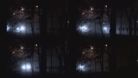 夜晚，汽车前灯发出的强光穿透了道路上的雾，由于雾霾能见度很低高清在线视频素材下载