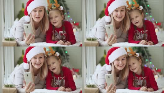妈妈和女儿用手机和家人朋友一起唱首歌，祝新年快乐。2019冠状病毒感染的肺炎疫情下远程在线圣诞庆祝活动。高清在线视频素材下载