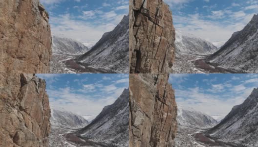 这是初春大雪纷飞的山峡岩石旁的跨度的鸟瞰图。高清在线视频素材下载