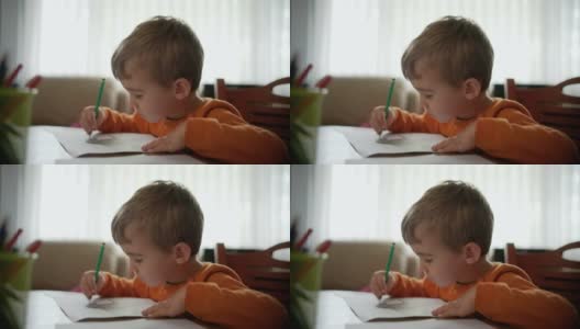 小男孩在家里画彩页高清在线视频素材下载